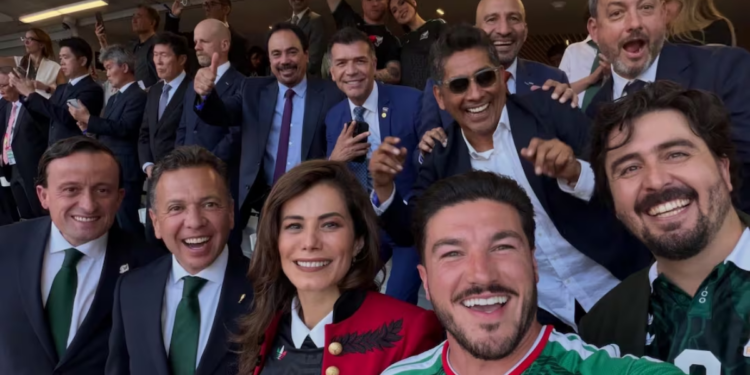 Group Selfie of Smiling Professionals at a Formal Event, with a Woman in a Red Jacket and a Man in a Green Jersey in Front. - Entre Regios