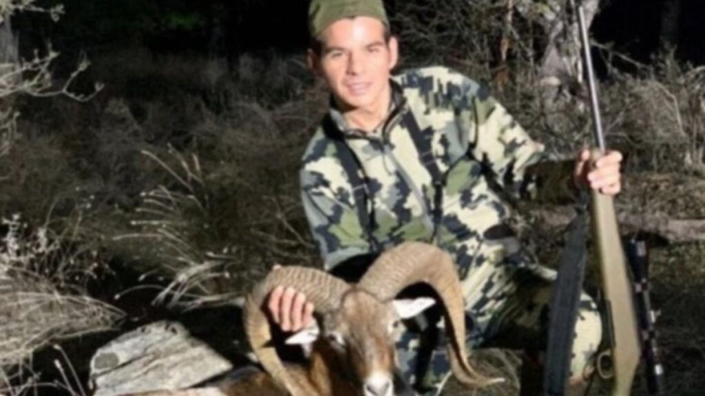 Hunter in Camouflage Posing with a Large Horned Ram, Rifle Resting Beside Him in a Desert Brush Setting - Entre Regios