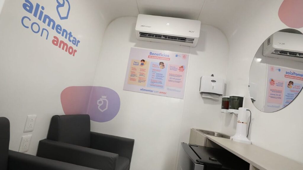 Interior of a Small White Clinic Nook with Two Black Armchairs, Wall Logo Reading 'alimentar Con Amor', and Posters on the Wall Near an Air Conditioner and a Counter with a Sink and Blender. - Entre Regios