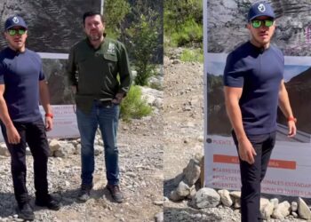 Two Men Stand on a Rocky Site Beside a Large Project Banner with Maps and Bridge Photos in the Background. - Entre Regios