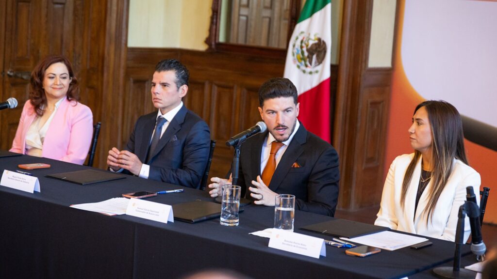 Cero-clausuras - Entre Regios Panel of Four Professionals at a Formal Panel Discussion, Microphones and Documents on the Table, Mexican Flag in the Background. - Entre Regios